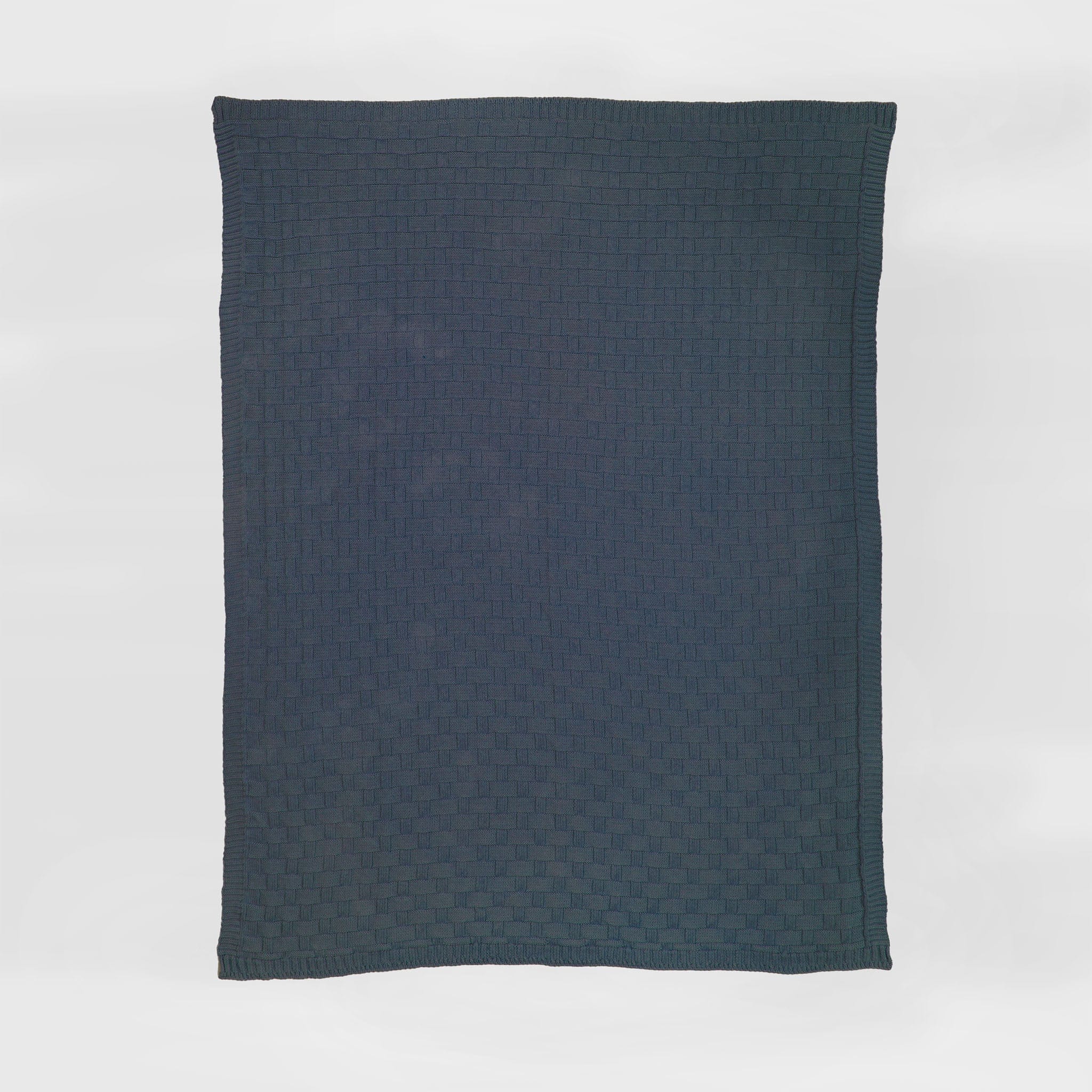 A navy rectangular Basketweave Throw Blanket by in2green, made from recycled yarns and featuring a subtle check pattern, is shown against a white background for an eco-friendly accent.