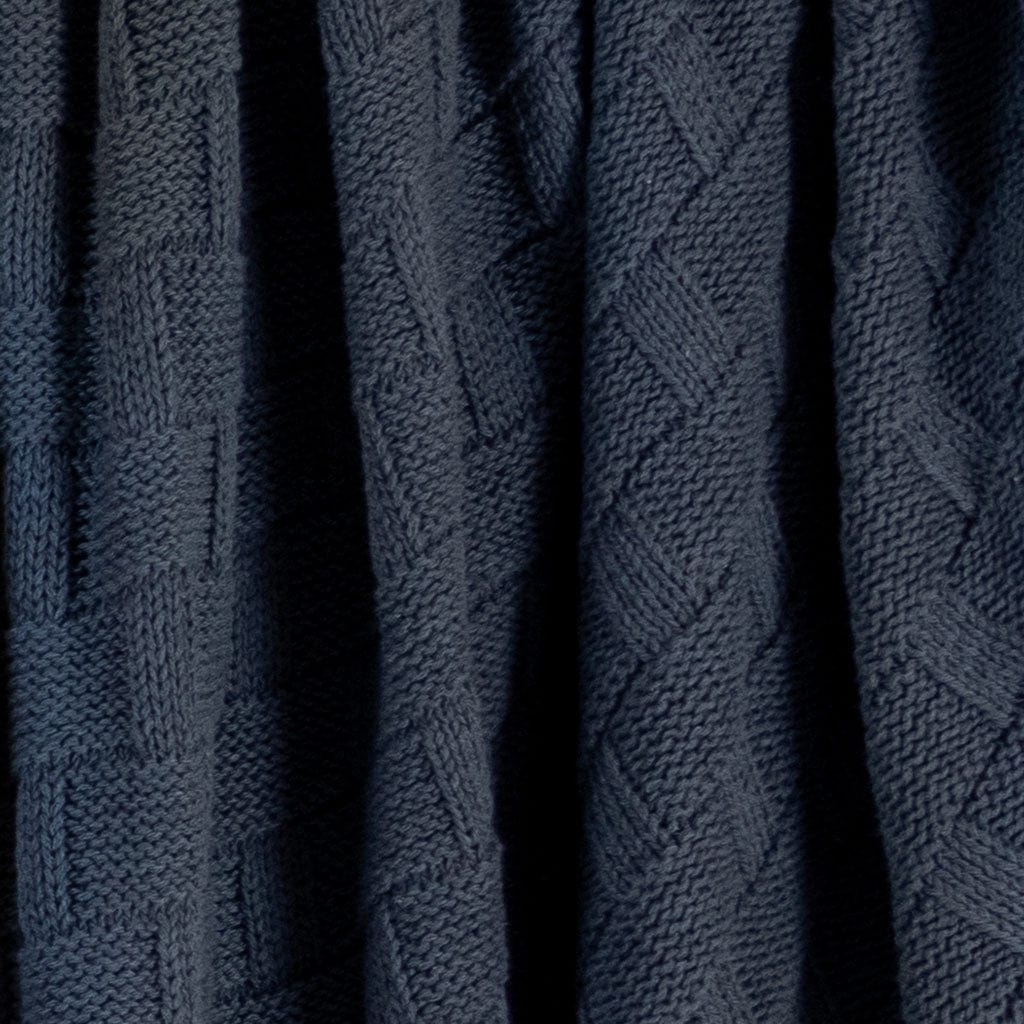 The Basketweave Throw Blanket by in2green features a dark blue, textured geometric pattern of interlocking rectangles and diagonal lines, crafted from sustainable recycled yarns for an eco-friendly touch.