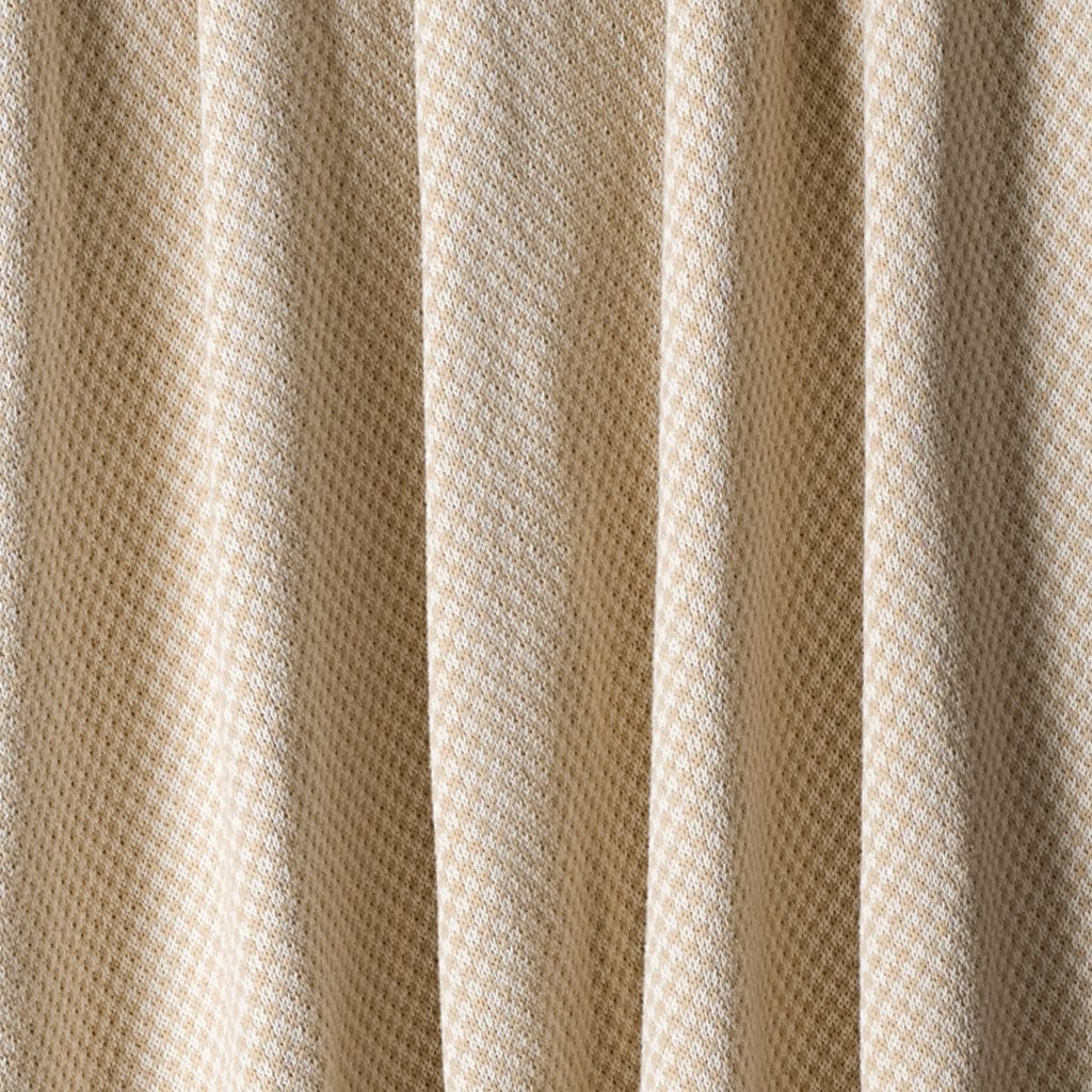 Close-up of the in2green Checkerboard Throw Blanket shows beige textured fabric with a subtle diamond pattern in vertical folds—ideal for modern decor or an upcycled cotton accent.