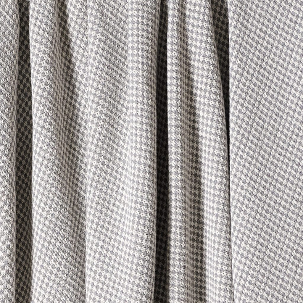 The in2green Checkerboard Throw Blanket features a gray and white houndstooth pattern with soft folds and draping, ideal for a modern touch to your space.