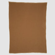 The Checkerboard Throw Blanket, rectangular and brown with a subtle textured pattern, is made from sustainable upcycled cotton and displayed flat on a white background—perfect for cozy living.