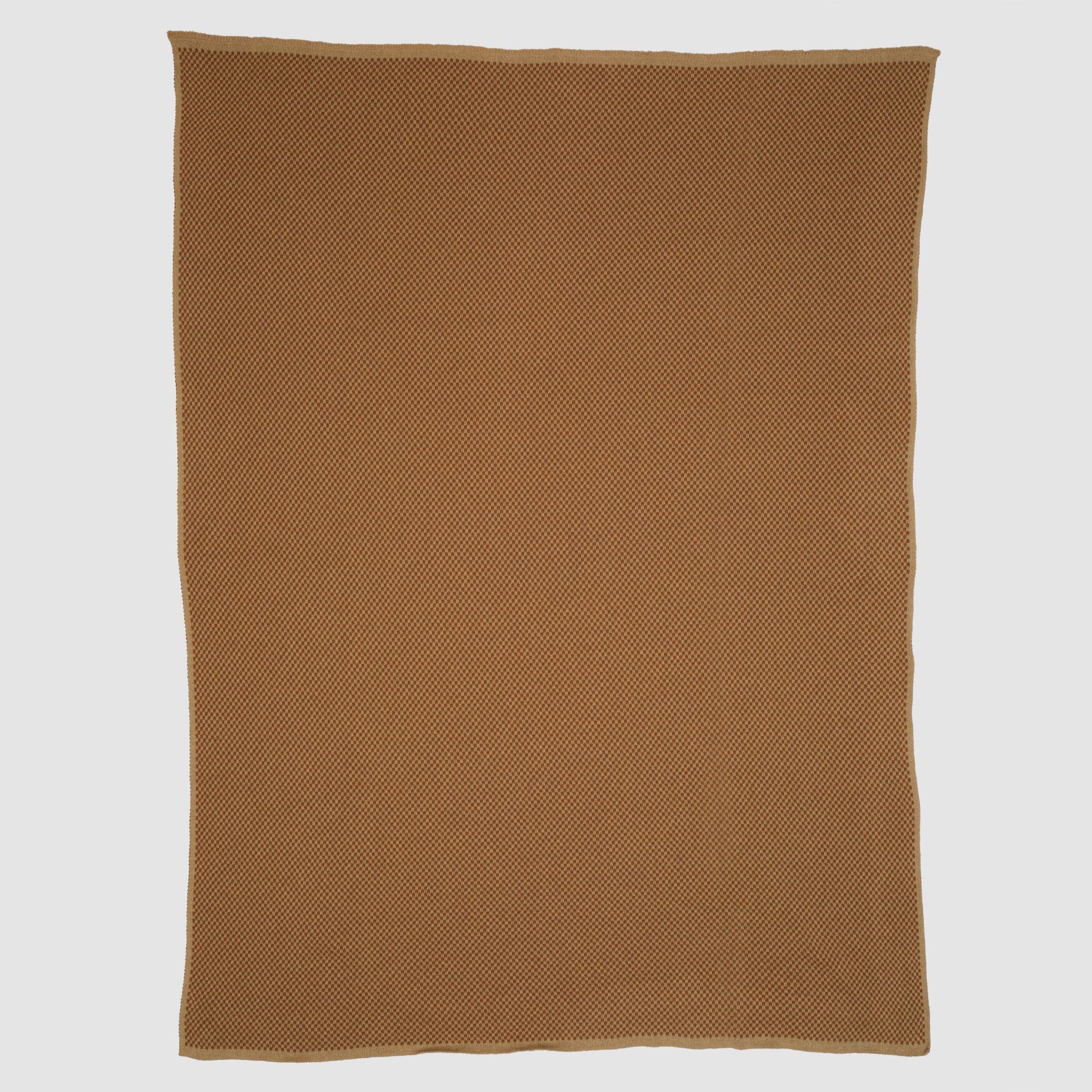 The Checkerboard Throw Blanket, rectangular and brown with a subtle textured pattern, is made from sustainable upcycled cotton and displayed flat on a white background—perfect for cozy living.