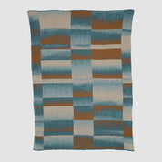 The in2green Plaid Ombre Throw Blanket features a geometric pattern of irregular rectangles in blue, rust, and beige with a soft gradient texture.