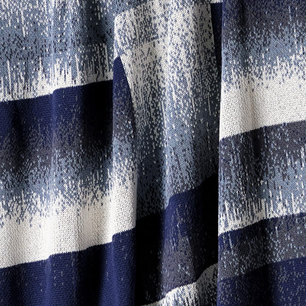Close-up of in2green's Plaid Ombre Throw Blanket, showcasing textured horizontal navy, white, and light blue stripes—a stylish modern choice crafted from recycled yarn.