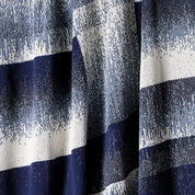 Close-up of in2green's Plaid Ombre Throw Blanket, showcasing textured horizontal navy, white, and light blue stripes—a stylish modern choice crafted from recycled yarn.