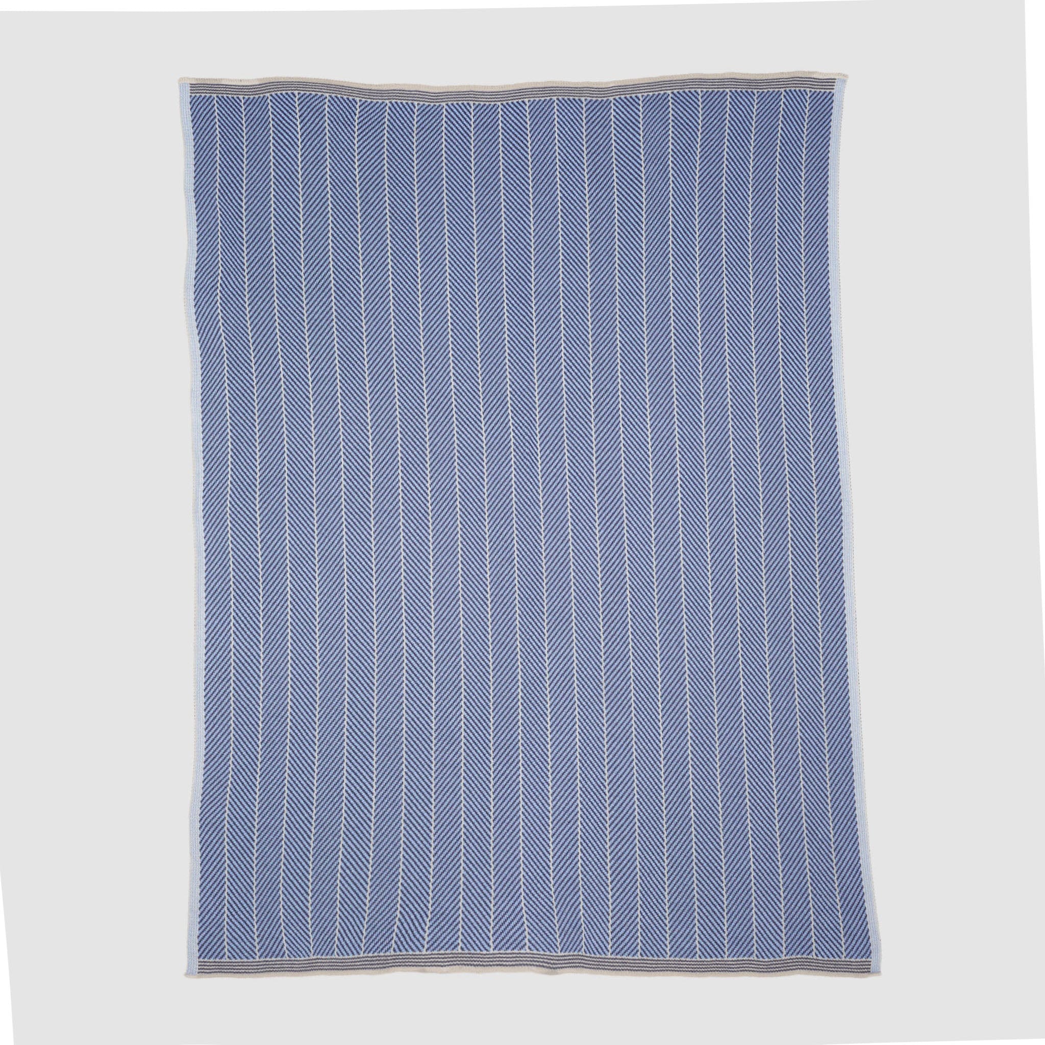 The in2green Poly Herringbone Edge Throw Blanket is a rectangular blue and white striped outdoor throw with a subtle herringbone knit and beige borders, made from recycled polyester, shown flat on a white background.