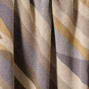 Close-up of the Southwest Arrows Throw Blanket, showcasing beige, gray, and yellow stripes with a central vertical fold that reflects the warm hues and timeless style of Southwestern desert textiles.