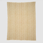 The Sand Stone Throw Blanket features a cream background with rows of small, evenly spaced yellow and brown geometric patterns, all crafted from eco-friendly yarns.