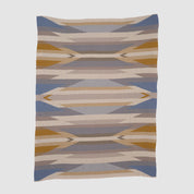 The Southwest Arrows Throw Blanket features geometric Southwestern-inspired patterns in blue, tan, beige, gray, and mustard—evoking desert landscapes—and is shown flat on a white background.