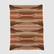 The Southwest Arrows Throw Blanket is a rectangular woven blanket with a geometric pattern in shades of brown, tan, rust, and beige, inspired by desert landscapes and classic Southwestern textiles.