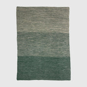 The in2green Textured Ombre Throw Blanket features three horizontal color blocks in green and gray with a subtle ribbed texture on a plain background.