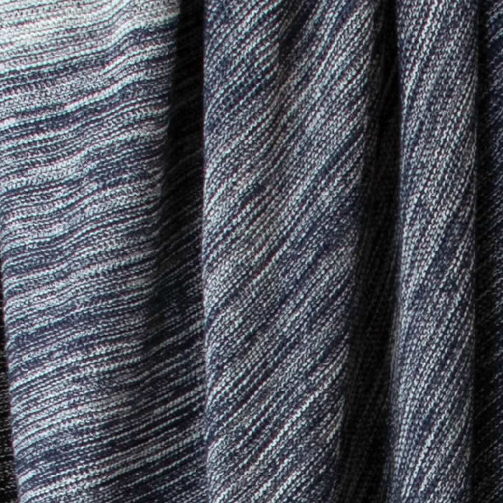 A close-up of the ribbed texture on the in2green Textured Ombre Throw Blanket shows dark blue and white woven fabric with horizontal and diagonal lines, crafted from recycled cotton for sustainability.