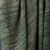 Close-up of green and beige woven fabric with subtle horizontal patterns and gathered pleats, echoing the ribbed texture of the in2green Textured Ombre Throw Blanket.