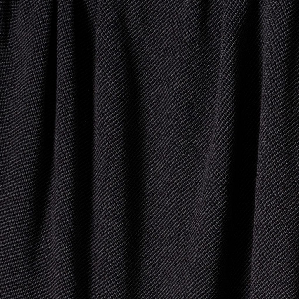 Close-up of in2green Wool Cardigan Throw Blanket in black, showing washable wool fabric with vertical folds and a subtle diagonal weave pattern.