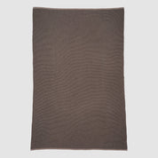 The in2green Wool Cardigan Throw Blanket, a rectangular solid brown piece with a textured surface, is laid flat on a light gray background.