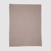 The in2green 100% Merino Wool Links Throw Blanket is a minimalist, light brown throw with a white border, crafted from soft wool and displayed flat on a light grey background.