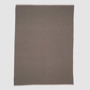 The in2green 100% Merino Wool Links Throw Blanket, shown flat on a white background, features subtle light edges and delivers minimalist elegance in a simple rectangular design.