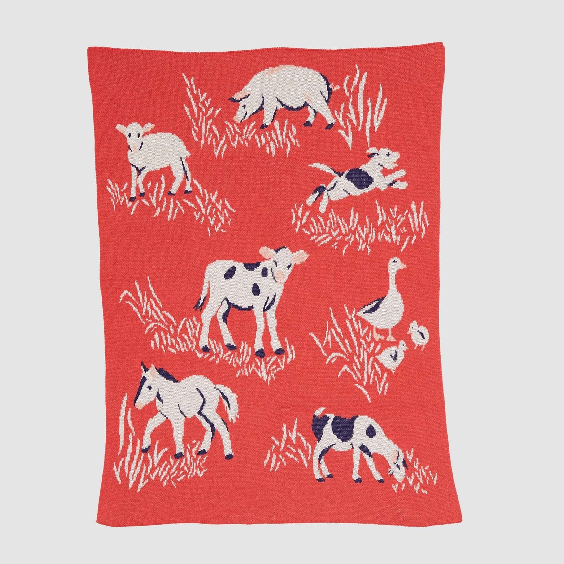 The Baby Farm Blanket by in2green is made from recycled cotton and showcases delightful white and black illustrations of cows, a horse, sheep, a dog, and a duck set against grass patterns.