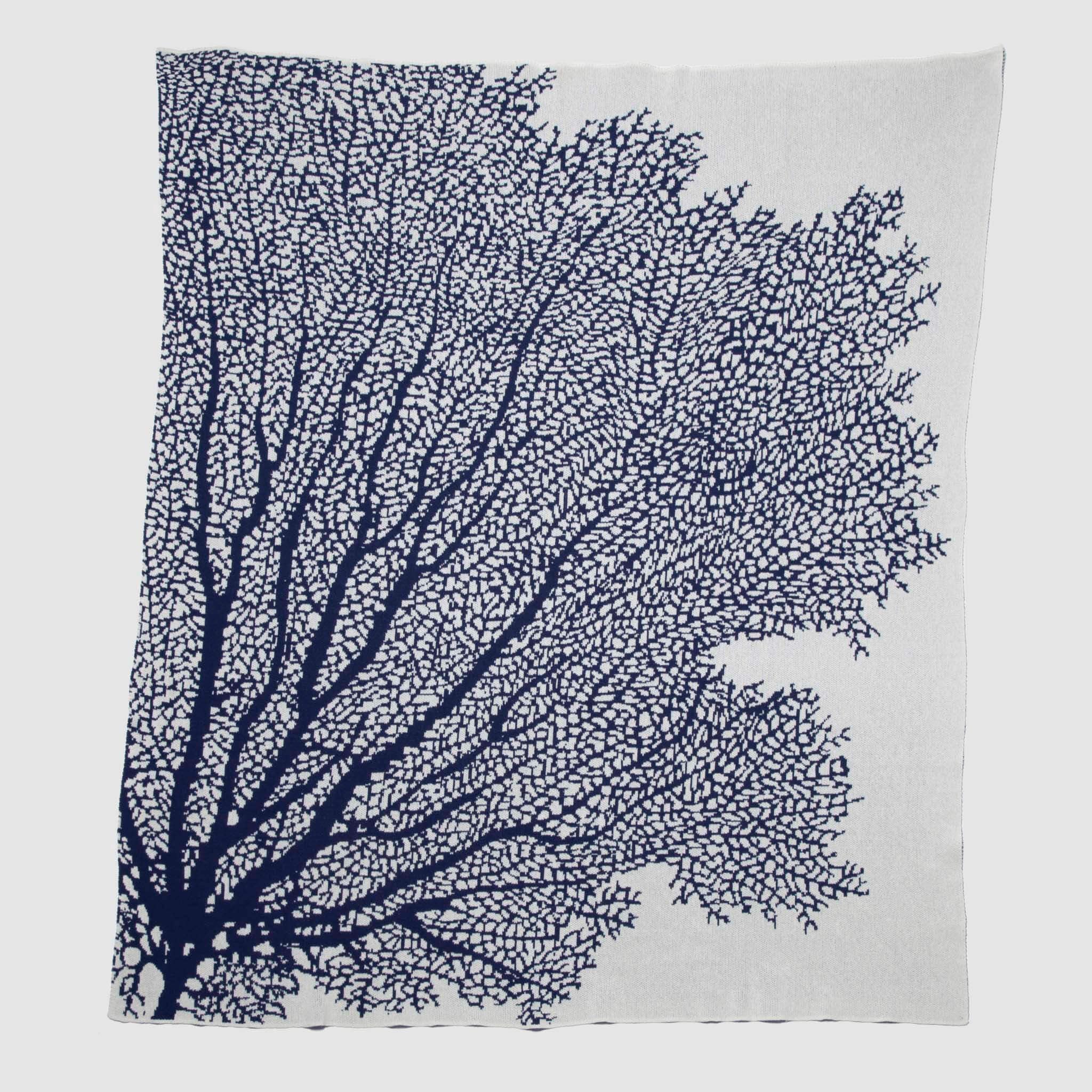 Add coastal flair to your beach house with the in2green Fan Coral Throw Blanket, featuring a white fabric accented by dark blue coral branches spreading from the lower left corner—a chic and stylish addition to any space.
