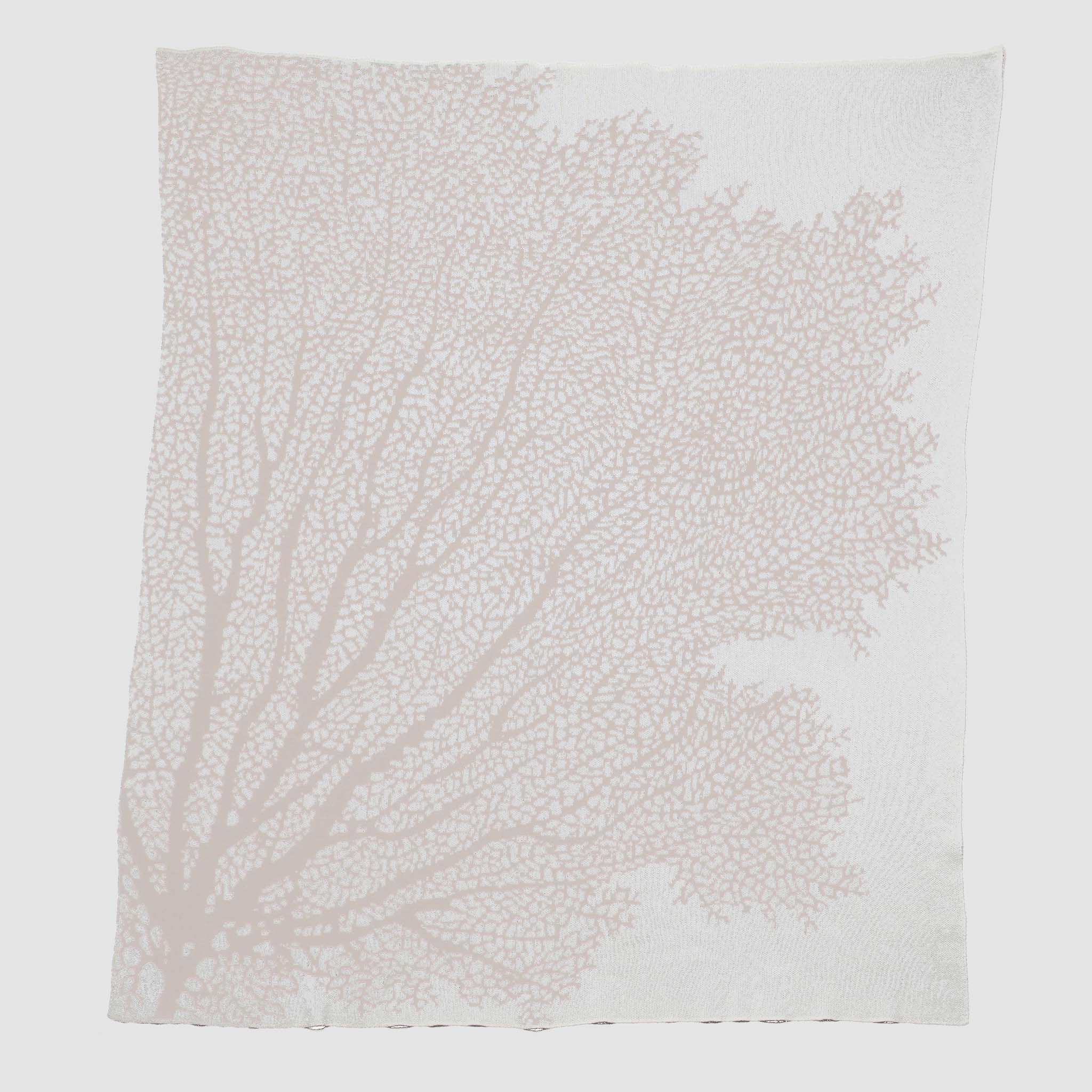 The in2green Fan Coral Throw Blanket features a white fabric with a light pink coral pattern—ideal for adding coastal charm to your beach house décor.