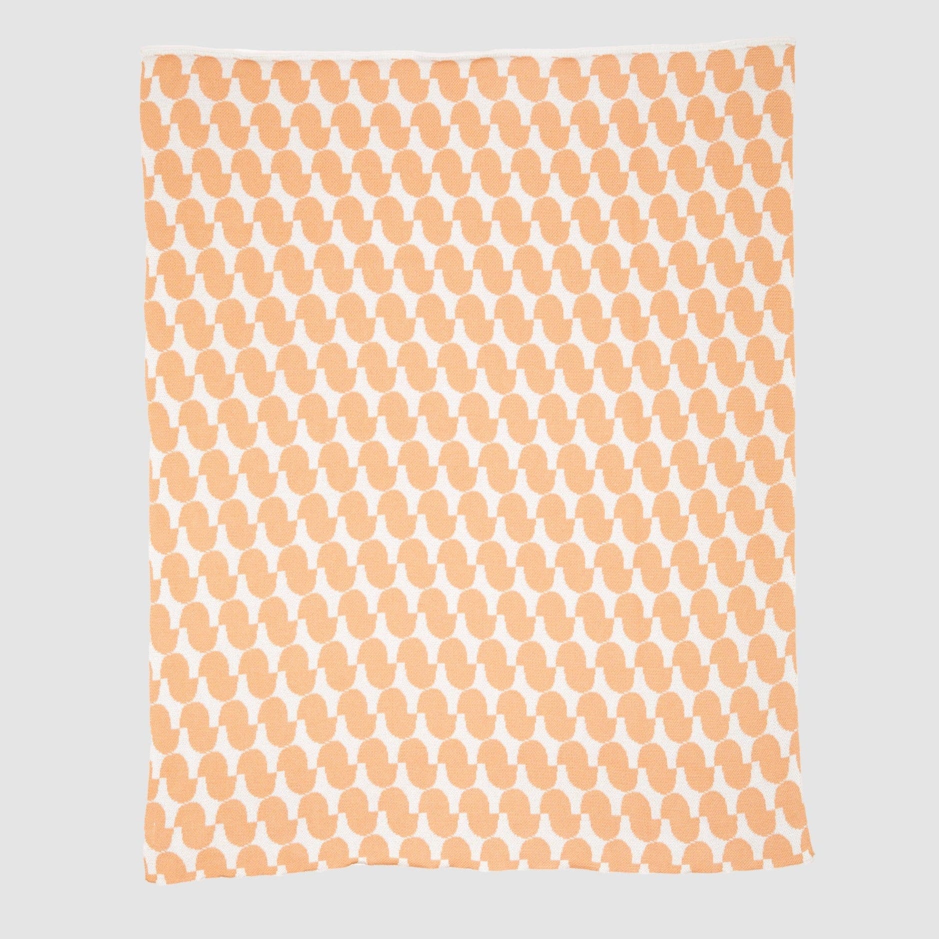 The Poly Juki Throw Blanket by Petra Kaksonen from in2green features an orange and white abstract pattern made from recycled polyester, displayed on a plain background.