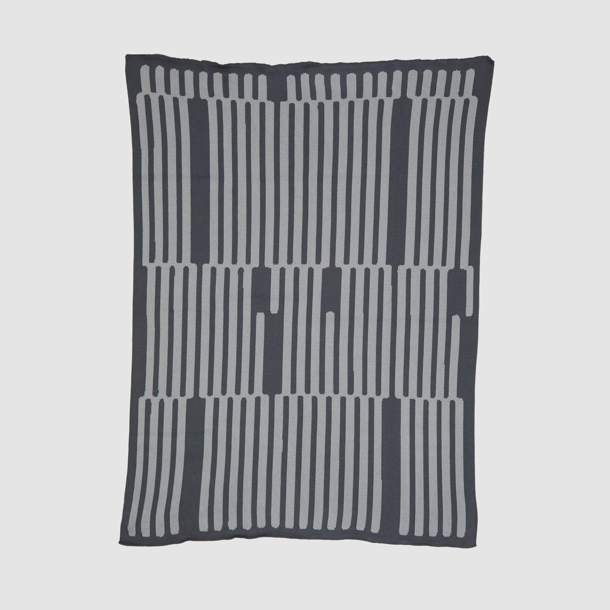 The Poly Retki Throw Blanket by Petra Kaksonen in charcoal and light grey