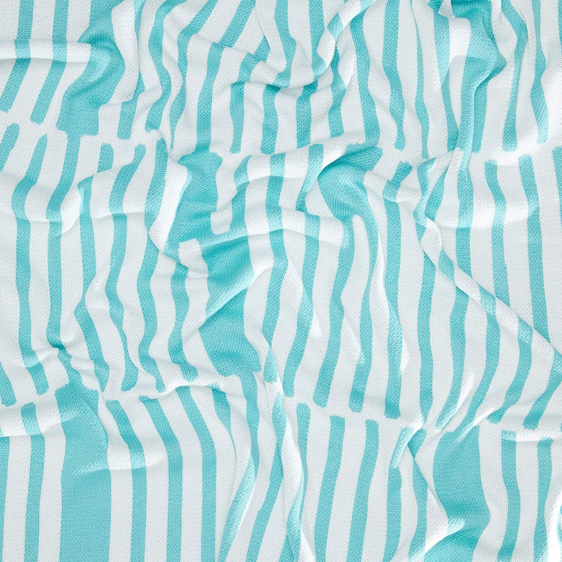 The Poly Retki Throw Blanket by Petra Kaksonen from in2green's outdoor collection showcases a crumpled fabric design with teal and white vertical stripes, crafted from recycled polyester.