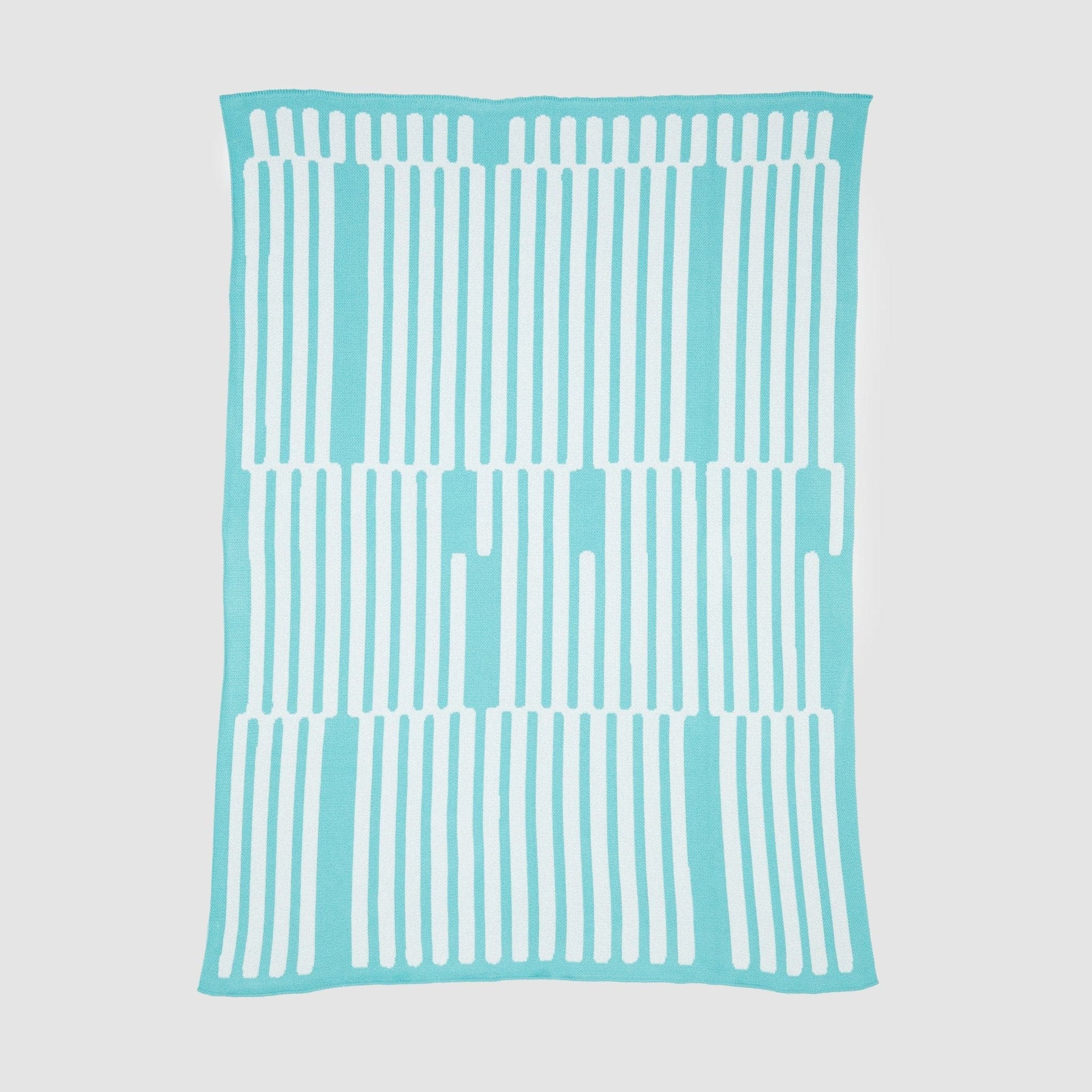 The Poly Retki Throw Blanket by Petra Kaksonen from in2green is part of the Kaareva outdoor collection. It features a turquoise design with vertical white stripes, crafted from recycled polyester for an eco-friendly touch, and lays flat on a white background.