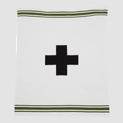 The in2green Swiss Cross with Stripes Throw Blanket is a white recycled knit featuring a central black Eco Swiss Cross, bordered by two green stripes near the top and bottom edges.