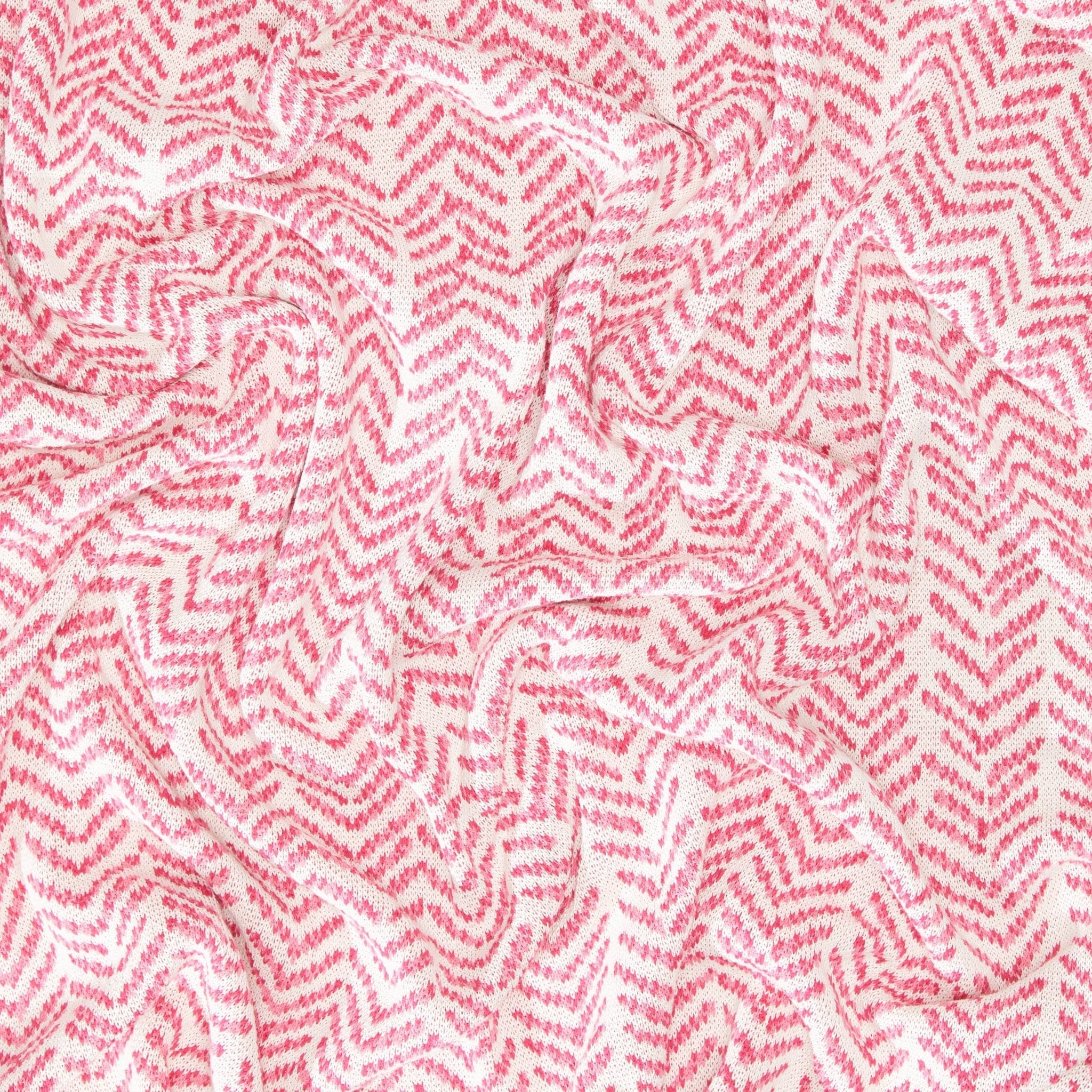 The In2Green Warrior Throw Blanket Pink boasts a striking zigzag pattern in red and white, with a gently crumpled texture, offering both comfort and style for individuals searching for warmth and supporting the breast cancer cause.
