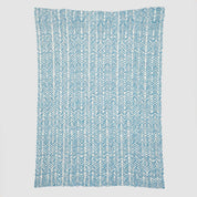Presenting the Warrior Throw Blanket Teal by In2Green, a rectangular cloth featuring a stylish blue and white herringbone pattern set against a white background, perfect for providing comfort during chemotherapy sessions.