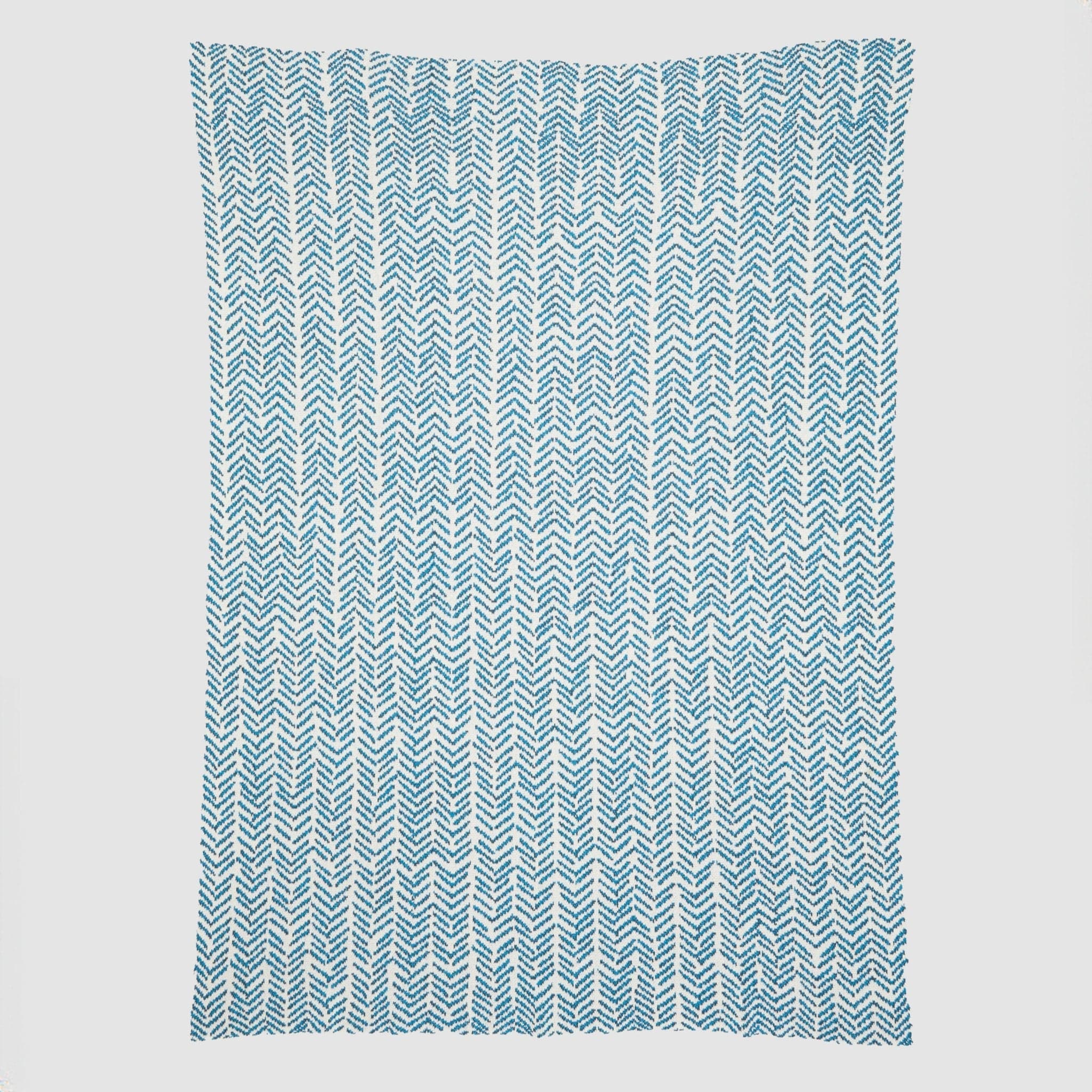 Presenting the Warrior Throw Blanket Teal by In2Green, a rectangular cloth featuring a stylish blue and white herringbone pattern set against a white background, perfect for providing comfort during chemotherapy sessions.