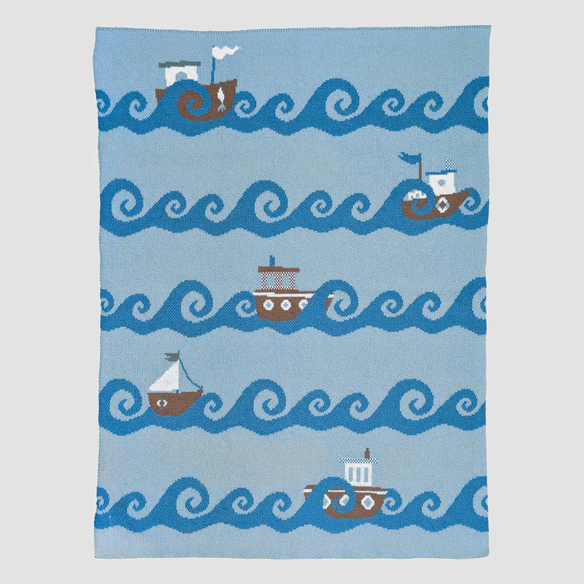 Blanket with boat and wave pattern on a blue background