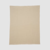 The Broken Zig Zag Throw Blanket is a beige, rectangular blanket with a repeating chevron pattern, made from recycled cotton yarns and shown laid flat on a plain white background.