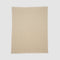 The Broken Zig Zag Throw Blanket is a beige, rectangular blanket with a repeating chevron pattern, made from recycled cotton yarns and shown laid flat on a plain white background.