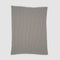 The Broken Zig Zag Throw Blanket, made from recycled cotton yarns and featuring a black and white chevron pattern, is shown flat on a white background.