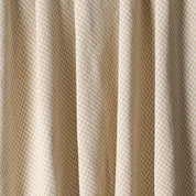 Close-up of the in2green Checkerboard Throw Blanket shows beige textured fabric with a subtle diamond pattern in vertical folds—ideal for modern decor or an upcycled cotton accent.