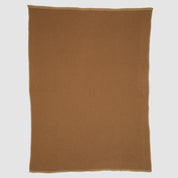 The Checkerboard Throw Blanket, rectangular and brown with a subtle textured pattern, is made from sustainable upcycled cotton and displayed flat on a white background—perfect for cozy living.
