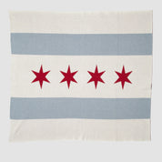 The Hometown Pride Flag - Cotton Sustainable Knit Blanket by in2green is a rectangular recycled cotton blanket, made in the USA, featuring two light blue horizontal stripes and four red six-pointed stars on a white background.