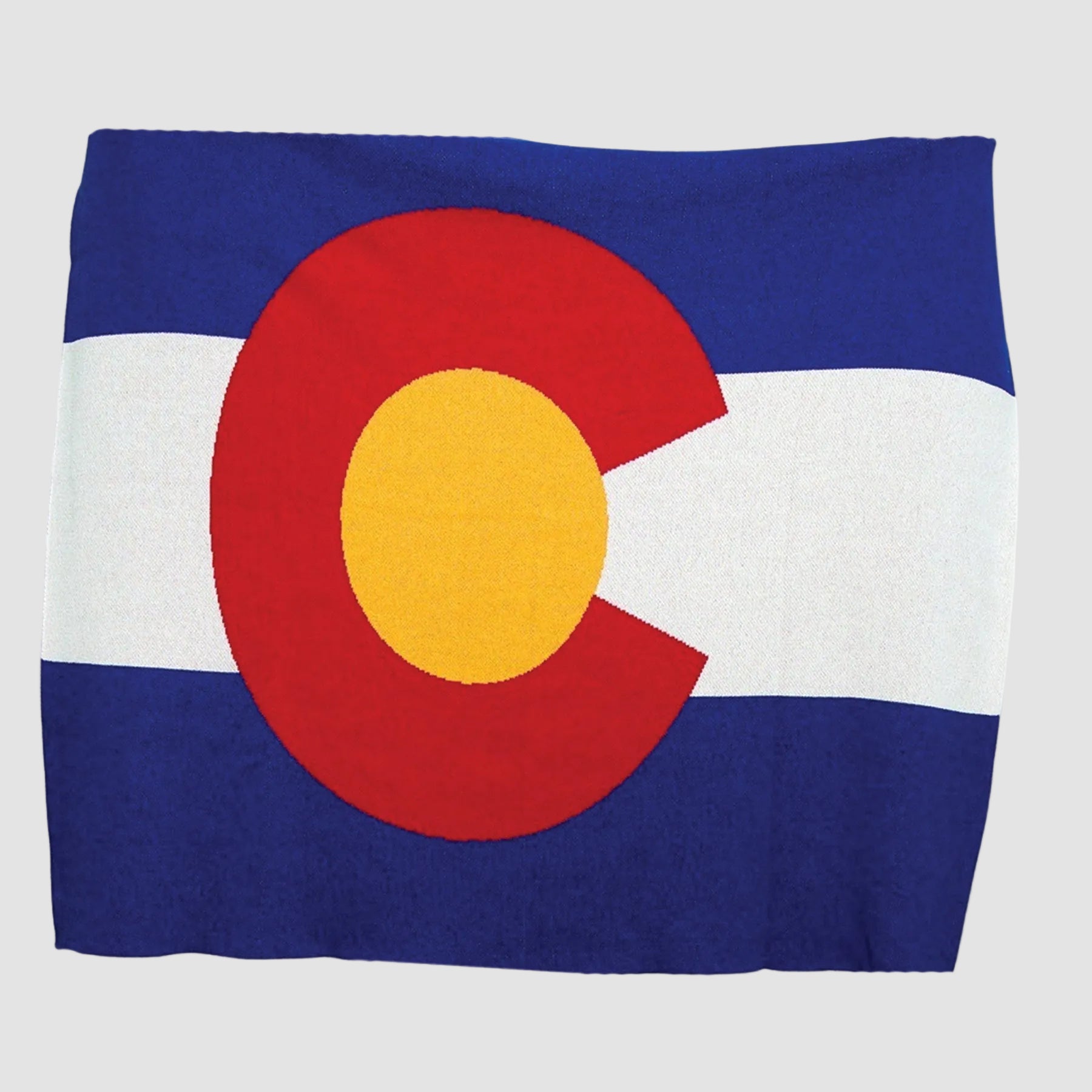 The in2green Hometown Pride Flag - Cotton Sustainable Knit Blanket features a rectangular design inspired by the Colorado state flag, with bold blue and white stripes and a red “C” encircling a yellow circle, and is proudly made in the USA.