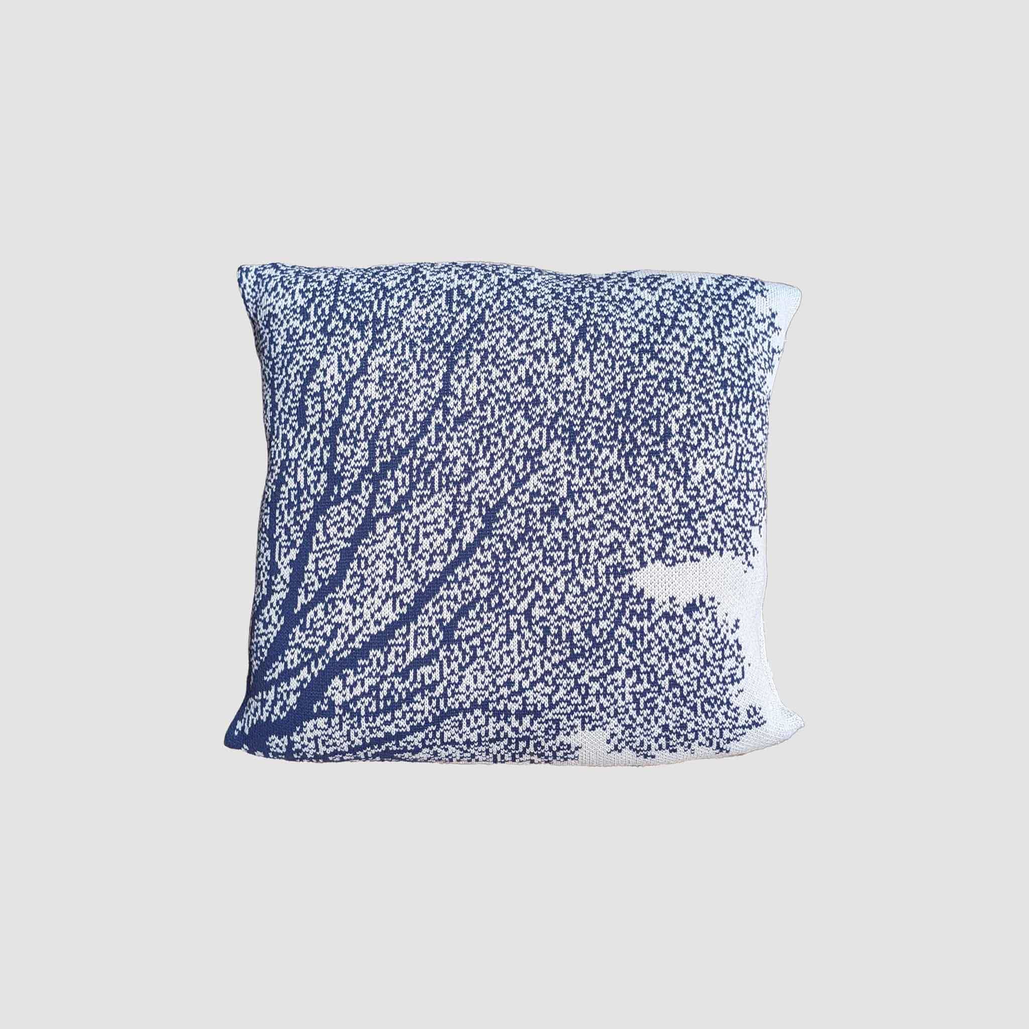 The in2green Fan Coral Pillow features a blue and white tree branch and leaf design, ideal for coastal decor. Displayed on a plain light gray background.