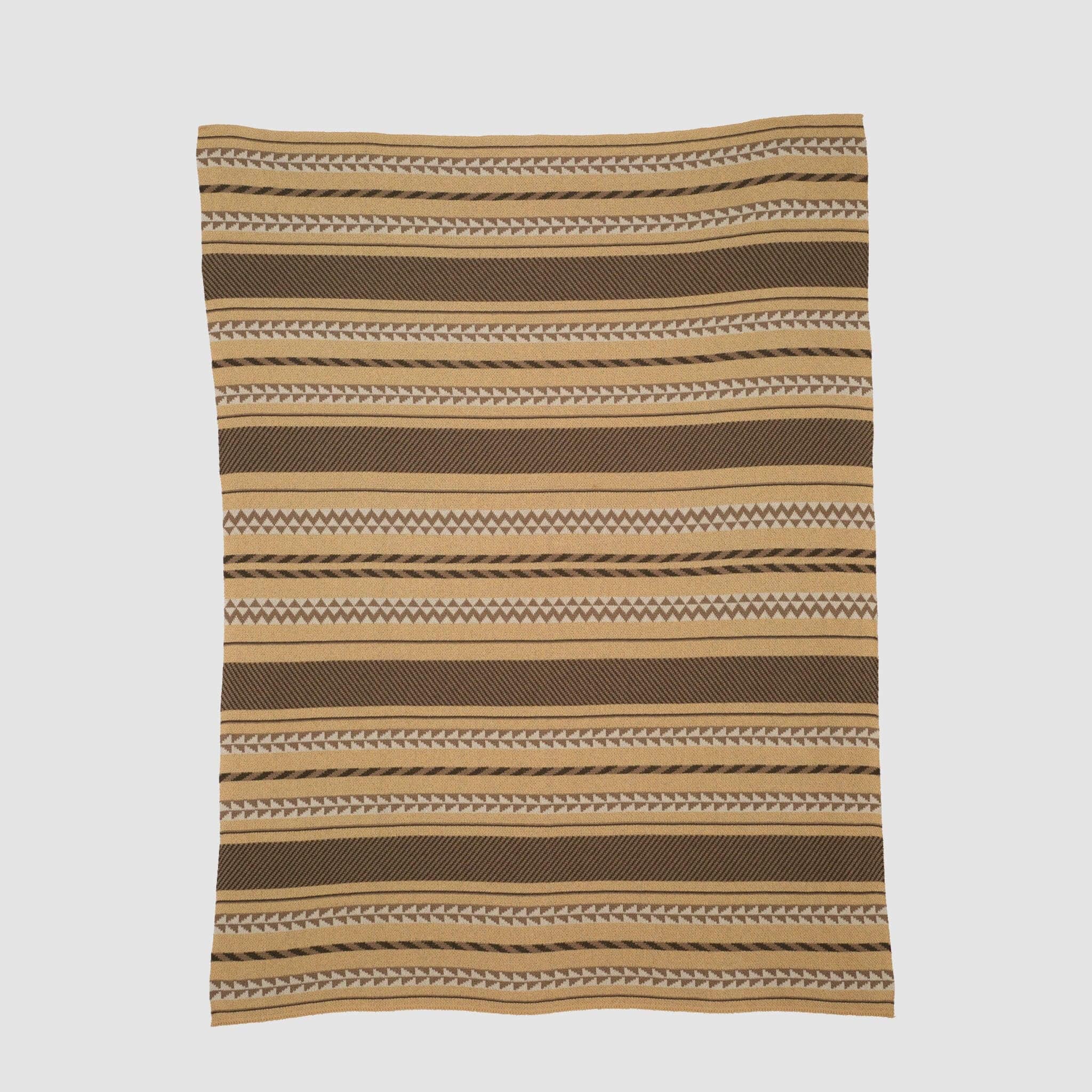 The in2green Geometric Stripe Throw Blanket is crafted from recycled cotton and features brown, tan, and cream horizontal stripes with geometric patterns—an eco-friendly accent for any room.