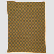 The in2green Gingham Plaid Throw Blanket, made from recycled cotton, features a mustard yellow and dark gray checkered pattern and is shown laid flat on a white background.