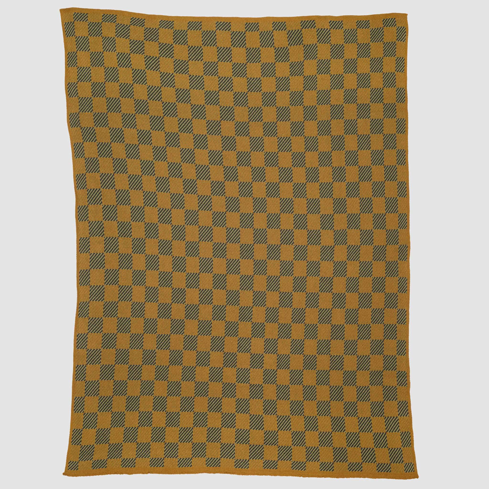 The in2green Gingham Plaid Throw Blanket, made from recycled cotton, features a mustard yellow and dark gray checkered pattern and is shown laid flat on a white background.