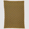 The in2green Gingham Plaid Throw Blanket, made from recycled cotton, features a mustard yellow and dark gray checkered pattern and is shown laid flat on a white background.