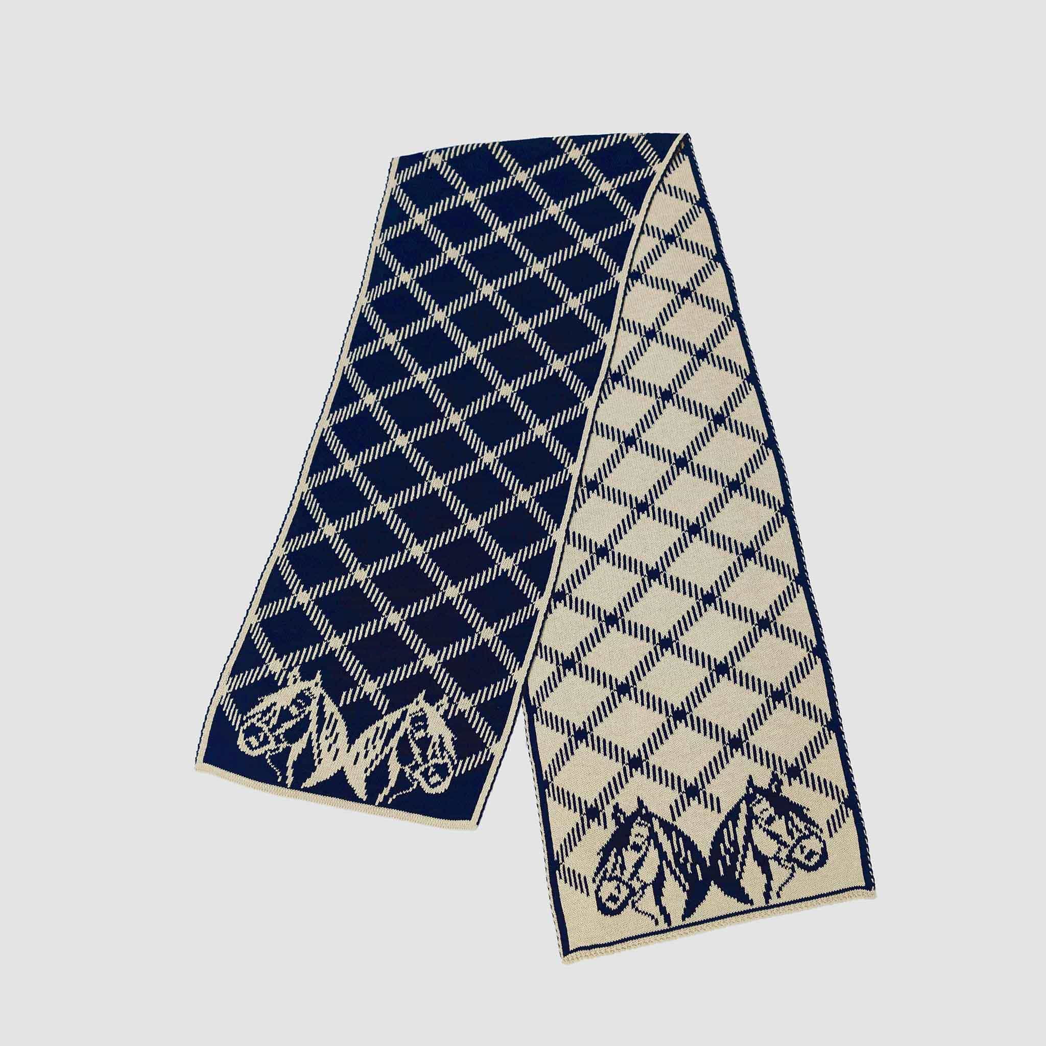 The in2green Equestrian Plaid Scarf features a navy and cream plaid pattern with horse head designs at each end, shown flat on a white background.