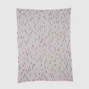 The Matrix Throw Blanket by Elodie Blanchard for in2green features thin, uneven vertical stripes and small rectangles in neutral tones on white, crafted with sustainable design principles.