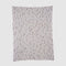 The Matrix Throw Blanket by Elodie Blanchard for in2green features thin, uneven vertical stripes and small rectangles in neutral tones on white, crafted with sustainable design principles.