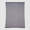 The in2green Poly Herringbone Edge Throw Blanket is a rectangular, sheer black mesh throw with vertical herringbone-knit lines and a solid black border, crafted from recycled polyester and shown flat on a plain background.