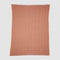 The in2green Poly Herringbone Edge Throw Blanket is a rectangular rust-colored outdoor throw with a white herringbone pattern, made from recycled polyester and shown flat on a white background.